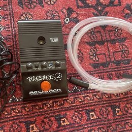 Černý kytarový předzesilovač s nápisy AMPLIFIER TALBOX, BANSHEE 2 a ROCKRON TECHNOLOGY FOR GUITARISTS. Zařízení má několik ovládacích knoflíků, přepí…