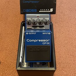 Modrý efekt pedál značky BOSS v originální krabici. Na pedálu jsou nápisy Compressor, CP-1X a čtyři ovládací prvky s popisky LEVEL, ATTACK, RATIO a C…