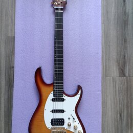 Elektrická kytara s tělem v barvě sunburst a bílým pickguardem. Na hlavě hředu je nápis Carl Martin. Kytara má tři humbuckery, z nichž každý nese náp…