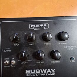 Černý přední panel basového předzesilovače s bílými nápisy. Uprostřed nahoře je logo MESA ENGINEERING a dole nápis SUBWAY BASS DI-PREAMP. Zařízení má…