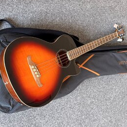 Akustická kytara s barevným přechodem (sunburst) od žluté přes oranžovou k černé, položená na černém obalu. Na obalu je viditelný nápis RITTER. Kytar…