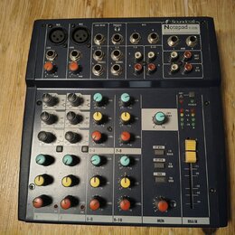 Černý mixovací pult značky Soundkraft, model Notepad 12 FX. Zařízení obsahuje několik vstupních kanálů s otočnými knoflíky v oranžové, žluté a modré…