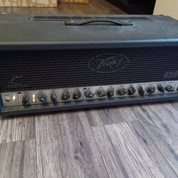 Černý kytarový zesilovač v texturovaném obalu s madlem na horní straně. Na přední mřížce je viditelné logo Peavey. Ovládací panel obsahuje řadu knofl…
