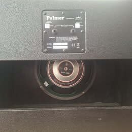Černá reproduktorová bedna s texturovaným povrchem. Na zadní straně je kovový štítek s nápisy „Palmer“, „ENGINEERED BY Eminence“, „POWER HANDLING: WA…