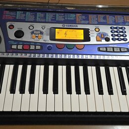 Elektronický klavír v černé barvě s modrým ovládacím panelem a dvěma integrovanými reproduktory po stranách. Na panelu je viditelné logo YAMAHA a ozn…