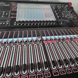Černý digitální mixovací pult s červenými detaily na hranách. V horní části je nápis DiGiCo SD9, displej a ovládací prvky. Spodní část obsahuje velké…