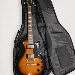 Elektrická kytara s trupem v barevnosti sunburst a černým pickguardem, umístěná v černém softcasu. Na hlavě hmatníku je bílý nápis Epiphone a zlatý n…