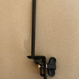Černý kovový držák s dlouhou rukojetí a utahovacím knoflíkem. Na boku knoflíku je vyryto logo „B“. Povrch je matný s mírnými známkami používání.