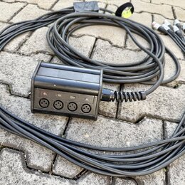Černý rozbočovací kabel s plastovým rozdělovačem. Na přední straně rozdělovače jsou čtyři konektory XLR a nad nimi nápisy 01., 02., 03. a 04. Kabel j…