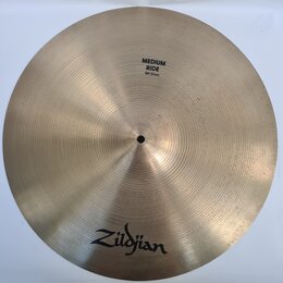 Kruhové činely v bronzové barvě s jemným žilkováním povrchu. V horní části je černý nápis MEDIUM RIDE 20"/51cm a v dolní části černé logo Zildjian. P…
