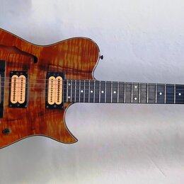 Elektrická kytara s polodupatým tělem v přirozené dřevěné barvě s výraznou masou. Na hlavě hředu je vidět nápis CARVIN. Nástroj má dva humbuckery, hm…