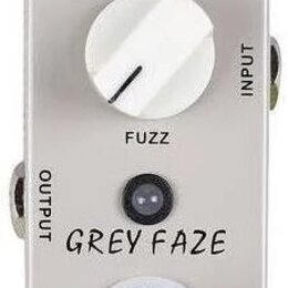 Šedý efekt pedál s bílým ovládacím knoflíkem. Na zařízení jsou nápisy DC IN, VOLUME, INPUT, FUZZ, OUTPUT a model GREY FAZE. Ve spodní části je umístě…