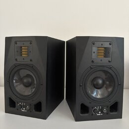 Dva černé studiové monitory v plastovém nebo lakovaném provedení. Každý reproduktor má v horní části žlutý páskový výšek a ve spodní části kruhový ba…