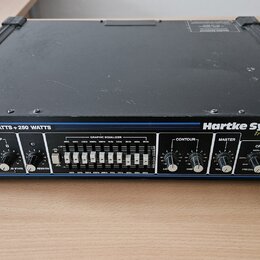 Černý rackový zesilovač s nápisy MODEL: HA5000 a 250 WATTS + 250 WATTS. Na pravé straně je bílé logo Hartke Systems a pod ním nápis Transient Attack.…