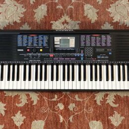 Černý digitální klavír s bílými a černými klávesami. Na levé straně panelu je nápis YAMAHA a vpravo označení modelu PSR-220. Horní část přístroje obs…