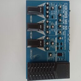 Modré multifunkční efektové pedály s nápisem BOSS ME-50 GUITAR MULTIPLE EFFECTS. Zařízení obsahuje tři stoupací spínače s označením OD/DS, MOD a DELA…