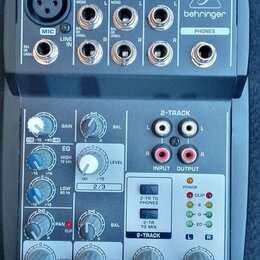 Šedý mixážní pult značky behringer s označením XENYX 502. Na horní části jsou vstupy MIC, LINE IN a výstupy MAIN OUT a PHONES. Spodní panel obsahuje…