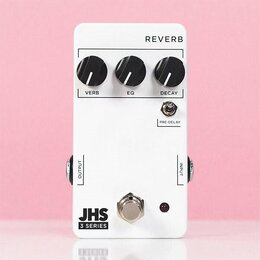 Bílý kytarový efekt s nápisem REVERB. Na horní straně jsou tři černé otočné ovířky s popisy VERB, EQ a DECAY, dále je zde přepínač označený PRE-DELAY…