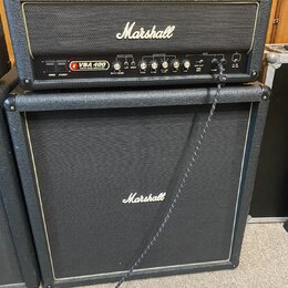 Černý basový kombozesilovač značky Marshall skládající se z hlavy a boxu. Na předním panelu hlavy je nápis VBA 400 VALVE BASS AMPLIFIER a logo Marsha…
