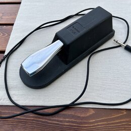 Černý sustain pedál s kovovým, chromovaným šlapadlem. Na horní části je vyražen nápis YAMAHA FC4. K pedálu vede černý kabel zakončený standardním jac…