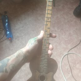 Dřevěný strunový nástroj s hruškovitým korpusem a hlavou zakončenou ornamentálním zahnutím. Nástroj je v tmavě hnědé barvě, povrch vykazuje známky op…