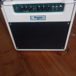 Bílý kytarový kombozesilovač s černou textilní maskou reproduktoru. Na předním panelu je nápis Ibanez TS015 a sekce s označením TUBE SCREAMER. Ovláda…