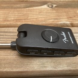 Černý kompaktní kytarový procesor Fender MUSTANG MICRO s integrovaným jackem. Na horní straně je umístěn jeden oválkový ovládací knoflík a nápisy Fen…