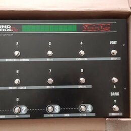 Černý programovatelný MIDI kontrolér s nápisy GROUND CONTROL Pro a Voodoo Lab. Zařízení obsahuje 12 stoupakových spínačů s čísly 1 až 8 a 9 až 4, dis…