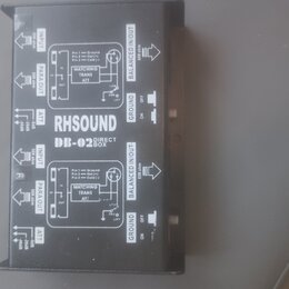 Fotografie zachycuje zadní stranu černé DI boxy s bílým technickým popisem. Na zařízení je uveden nápis RH SOUND DB-02 DIRECT BOX. Jsou zde viditelné…