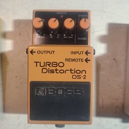 Oranžový efekt pedál s černým ovládacím panelem a černým spodním spínačem. Na zařízení jsou nápisy TURBO Distortion DS-2 a logo BOSS. Horní panel obs…