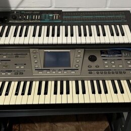 Dvě klávesové nástroje umístěné na sobě. Spodní šedý instrument nese nápisy Roland a DISCOVER 5 REALTIME ORCHESTRATOR. Horní černý instrument má nápi…