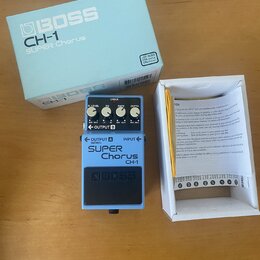 Kytarový efekt pedál značky BOSS, model SUPER Chorus CH-1 v šedé barvě s modrým horním panelem. Na pedálu jsou čtyři ovládací knofíky s popisky E LEV…