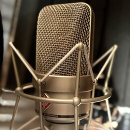 Kondenzátorový mikrofon v béžovém nebo šampaňském provedení s kovovou síťkou. Je umístěn v odpružívácím držáku stejné barvy. Na těle mikrofonu je vid…