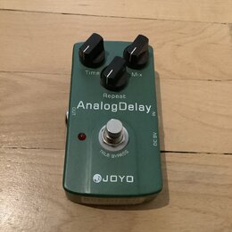 Zelený efekt pedál s nápisy AnalogDelay, JOYO a TRUE BYPASS. Na horní části jsou dva černé ovládací knoflíky s popisky Time a Mix, mezi nimi je nápis…