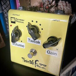 Žlutý kytarový efekt s nápisem TweakFuzz. Na horní části jsou vidět nápisy OUTPUT a INPUT a logo Seymour Duncan. Přístroj má tři ovládací knoflíky s…