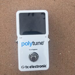 Bílý kytarový ladič s černým displejem. Na přední straně je modrý nápis polytune®, pod ním text true bypass a ve spodní části logo tc electronic®. Na…
