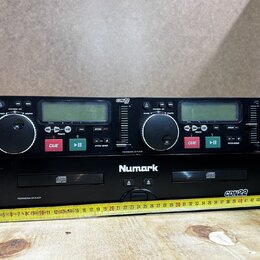 Dvě černé jednotky Numark CDN22 Professional CD Player. Horní zařízení má dvě ovládací jog-kola, displeje a tlačítka CUE a PLAY/PAUSE. Spodní zařízen…