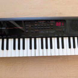 Černý přenosný digitální klavír s bílými a černými klávesami. Na levé straně je bílý nápis YAMAHA a model PSS-A50. Přístroj má ovládací panel s různý…