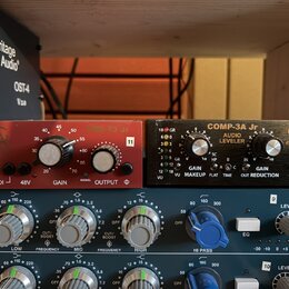 Fotografie zachycuje dva rackové audio procesory umístěné nad mixovací deskou. Levý červený přístroj nese nápisy PRE 73 Jr, GAIN, SIGNAL a OUTPUT. Pr…