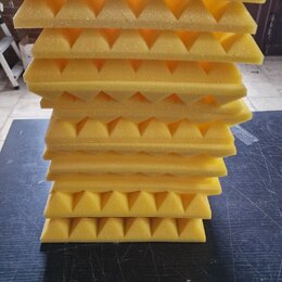 Stoh žlutých akustických absorbů z pěny s pyramidovým povrchem. Panely jsou naskládány na sebe na tmavém podkladu. Na fotografiích nejsou viditelné ž…