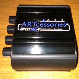 Černý kovový box s nápisy ARTccessories™ a SPLIT Mix 4 Passive Four Channel Mixer / Splitter. Na horní části je rovněž uveden nápis ART. Z levé stran…