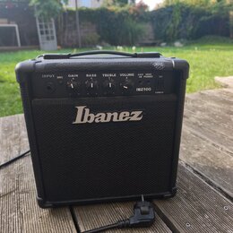Černý kytarový kombo zesilovač s logem Ibanez na přední mřížce. Na ovládacím panelu jsou nápisy INPUT, DIST., GAIN, BASS, TREBLE, VOLUME, AUX IN, HEA…