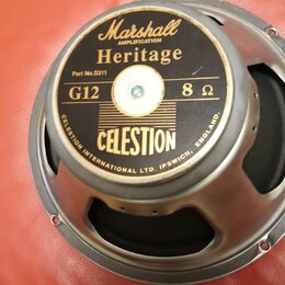 Kruhový reproduktor s kovovým rámem a černou membránou. Na středovém štítku jsou nápisy Marshall AMPLIFICATION Heritage, Part No.S311, G12 8 Ω a CELE…