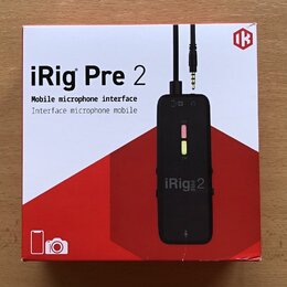 Fotografie znázorňuje krabici s produktem iRig Pre 2. Na bílo-červeném obalu je uveden název „iRig Pre 2“ a popis „Mobile microphone interface / Inte…