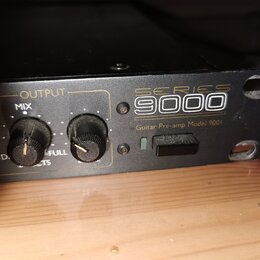 Černý rackový přístroj s nápisy SERIES 9000 a Guitar Pre-amp Model 9001. Na předním panelu jsou dva černé otočné ovratky s popisky OUTPUT, MIX a FULL…
