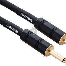 Dvě černé audio kabelové konektory se zlatými hroty. Na černých gumových krytech je bílý nápis BOSS. Povrch konektorů má v horní části vroubkování pr…