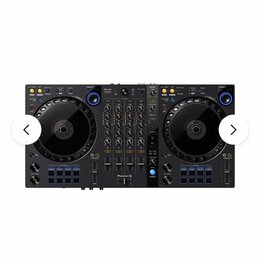 Černý DJ kontrolér s dvěma jog-wheels a centrálním mixážním sekcí. Na spodní části je vidět bílý nápis Pioneer DJ. Zařízení obsahuje zahlreiche modré…