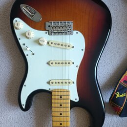 Elektrická kytara s telyem v provedení sunburst a bílým pickguardem. Kytara má tři snímače s bílými kryty, tři ovládací knoflíky s nápisem VOLUME a j…