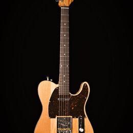 Elektrická kytara s přírodním dřevem těla a hředu. Na hlavě je viditelný nápis „Dunlop“. Kytara má tmavý hrací prkno a tmavě hnědý pickguard s bílými…