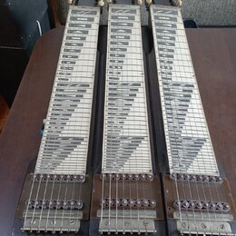 Tři stejné hmatníky pedal steel guitar z tmavého dřeva s bílými vložkami a černým rastrem. Každý hmatník má v horní části čtyři bílé ladičky a v doln…
